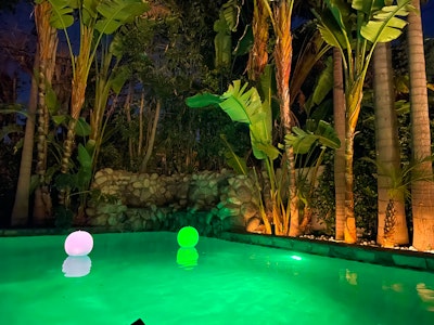 Pool glowing at night under string lights